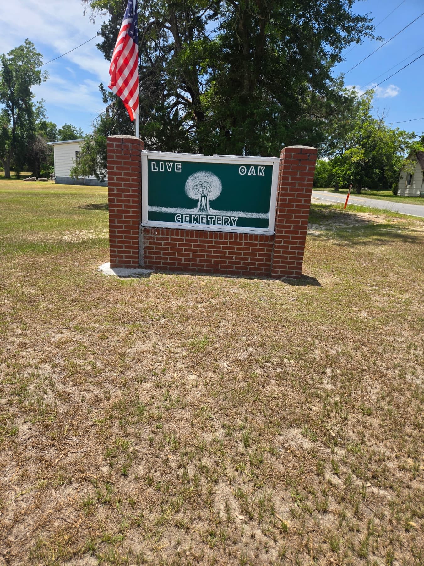 The Live Oak Cemetery sign, standing at the edge of the grounds